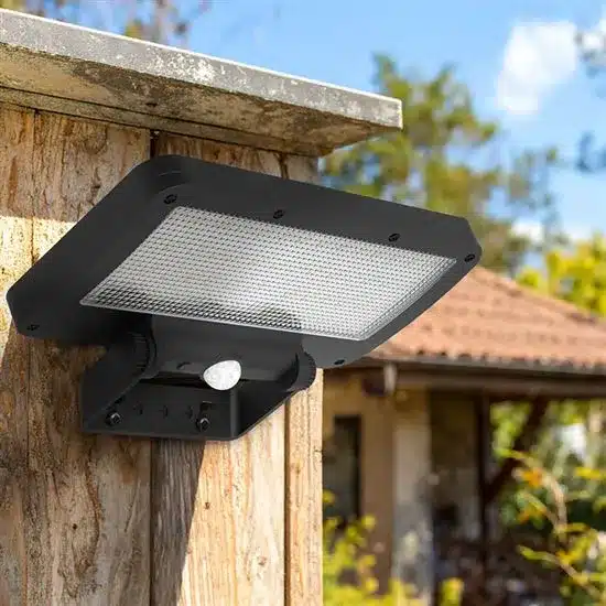 Inštalácia čierneho Solight LED solárne svetlo so senzorom na drevený plot pre ochranu kurníka.